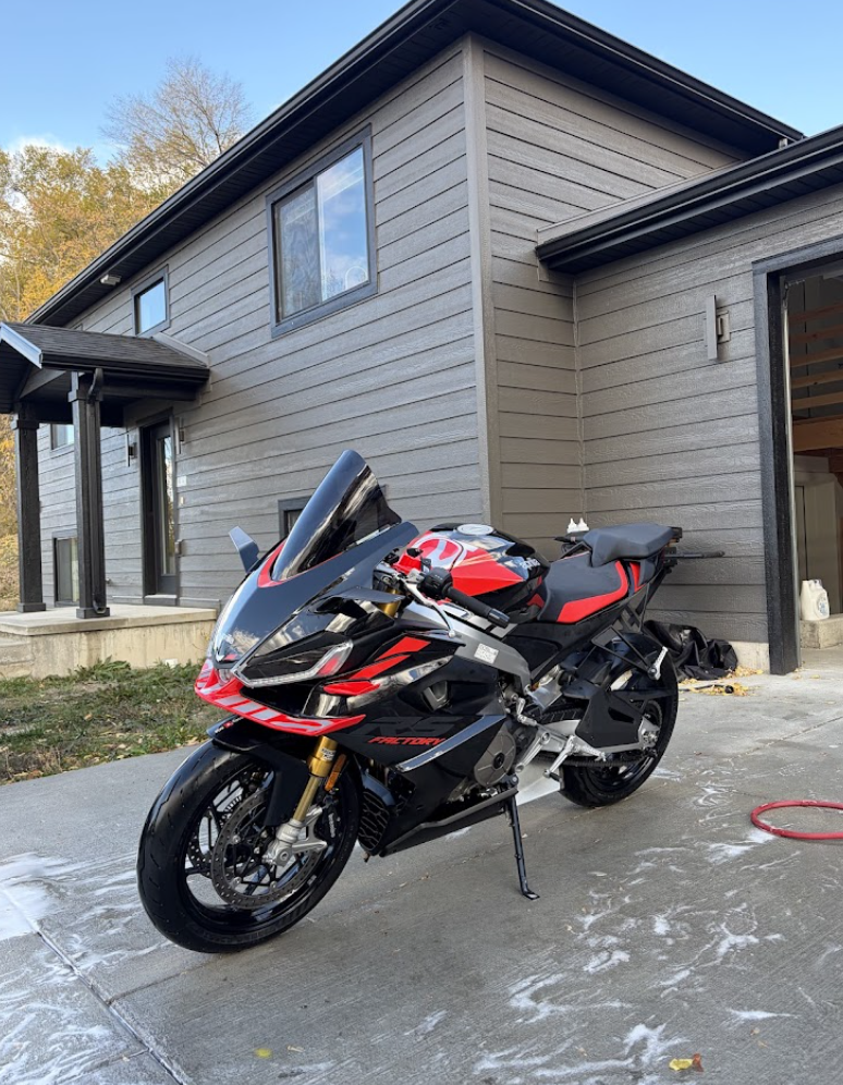 Sport motorcycle being washed on a driveway by a mobile detailer