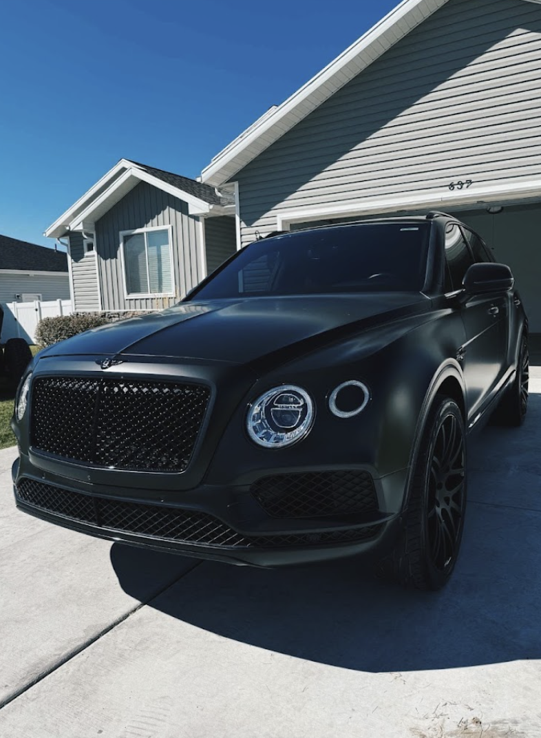 Freshly detailed matte black luxury SUV in a driveway in Alpine, Utah